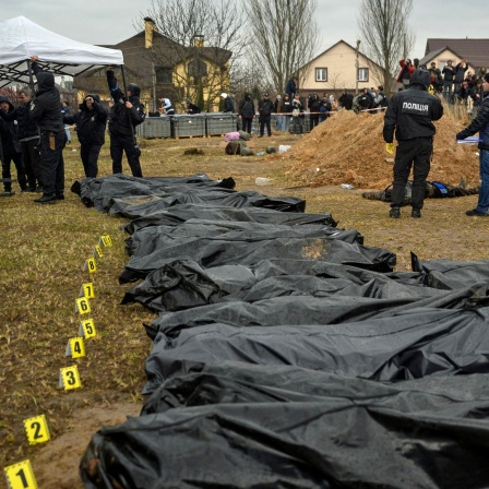 Leichen getöteter Zivilisten liegen in Butscha am Stadtrand von Kiew in schwarzen Säcken.