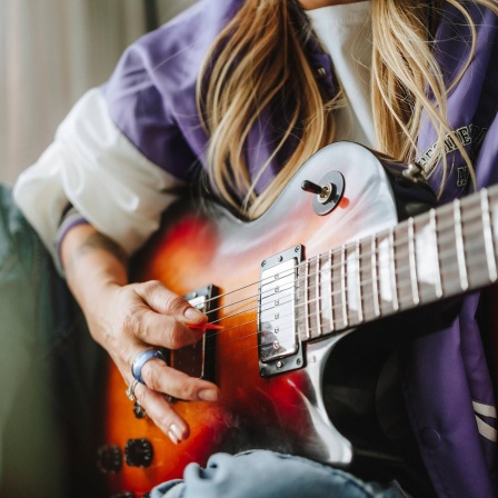Eine Frau spielt E-Gitarre. 