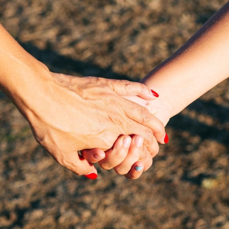 Symbolbild: Eltern und Kinder; eine Mutter hält die Hand ihrer Tochter