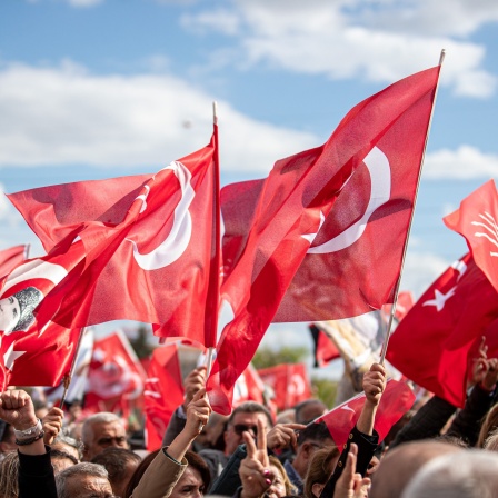 Menschen halten türkische Flaggen während einer Demonstration.