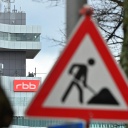 Ein Baustellenschild in Berlin weist auf eine Baustelle hin, im Hintergrund sieht man das Gebäude des RBB.