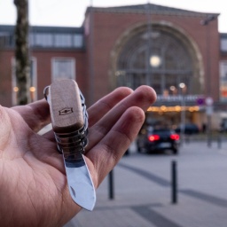 Ein Taschenmesser wird vor dem Kieler Hauptbahnhof in der Hand gehalten.