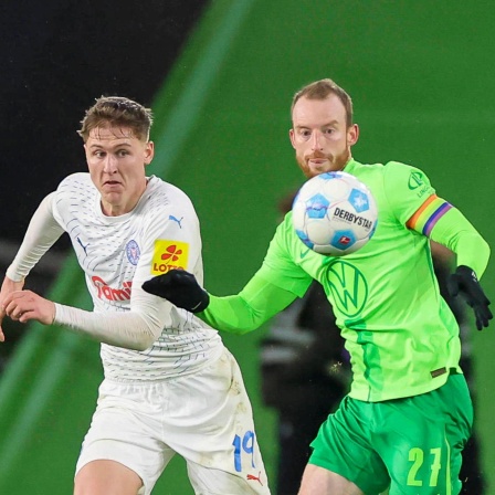 Wolfsburgs Maximilian Arnold und Kiels Phil Harres kämpfen um den Ball
