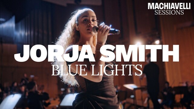 Jorja Smith hält ein Mikrofon in der Hand, über dem Bild ist der Schriftzug "Jorja Smith Blue Lights" zu sehen