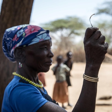 Eine Aufnahme aus dem Jahr 2018 zeigt eine Frau in einem Dorf in Uganda, die nach eigener Aussage die „Vorsitzende der Messerschneider“ in ihrem Stamm gewesen ist, bevor die weibliche Genitalverstümmelung (FGM) 2010 in Uganda verboten wurde. Sie zeigt das Werkzeug, mit dem sie junge Mädchen beschnitten hat. 