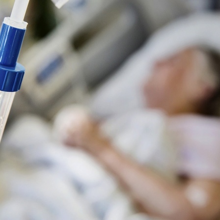 Eine Seniorin liegt im Krankenhaus an einem Tropf.