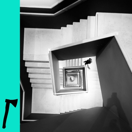 Schwarzweiß-Foto: Blick von oben in ein Treppenhaus.