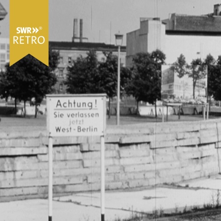 Straße im geteilten Berlin mit Mauer und dem Schild "Achtung, Sie verlassen jetzt Westberlin"