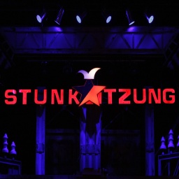 Das Logo der Stunksitzung wird von Bühnenscheinwerfern angeleuchtet