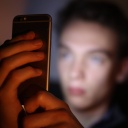Ein Jugendlicher schaut gebannt auf sein Smatphone