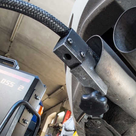 Ein Messschlauch eines Geräts zur Abgasuntersuchung für Dieselmotoren steckt im Auspuffrohr eines VW Golf 2.0 TDI in einer Werkstatt.