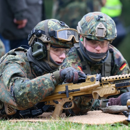 Zwei junge Soldaten an einem Maschinenegewehr.