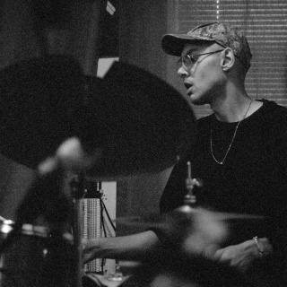 Ein Schwarz-Weiß-Foto von einem Schlagzeug spielenden Mann.