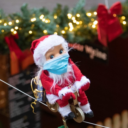 Ein kleiner radelnder Weihnachtsmann mit Maske bewegt sich auf einem Seil