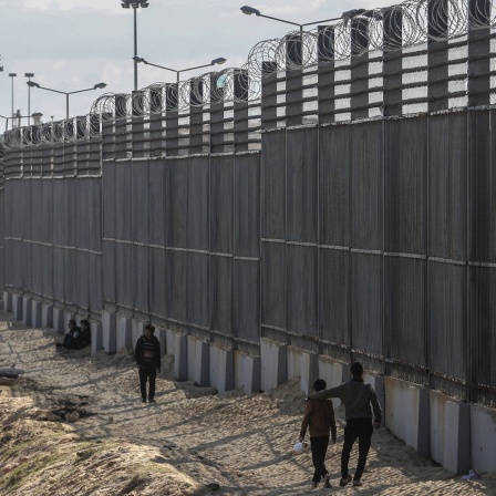 Palästinenser stehen an der Grenze zwischen dem Gazastreifen und Ägypten nahe Rafah.