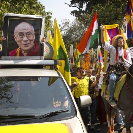 Exil-Tibeter in Indien demonstrieren anlässlich der Besetzung durch China vor 60 Jahren und tragen dabei neben Fahnen, auch ein Portrait des Dalai Lama mit sich.