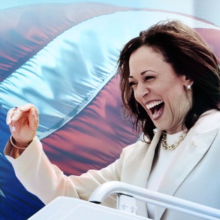 Kamala Harris jubelnd vor einer amerikanischen Flagge