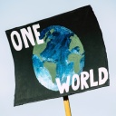 Tansparent mit dem Bild einer Weltkugel und dem Schriftzug "One World"