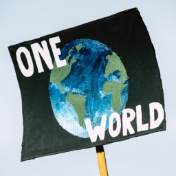 Tansparent mit dem Bild einer Weltkugel und dem Schriftzug "One World"
