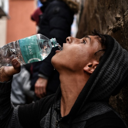 Ein palästinensischer Junge tringt Wasser aus einer Plastikflasche