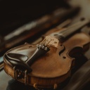 Wiederentdeckte Instrumente werden zu neuem musikalischen Leben erweckt. Zu sehen: Eine kleine Geige liegt auf einem Tisch, dahinter der geöffbete Geigenkasten.
