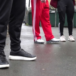 Vier Jugendliche stehen in einer Reihe und tragen jeweils eine Jogginghose.