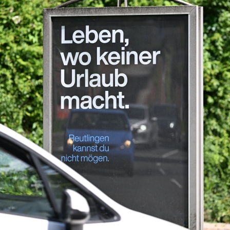 Der Werbespruch: &#034;Leben, wo keiner Urlaub macht. - Reutlingen kannst Du nicht mögen.&#034; hängt an einer Straße in Reutlingen