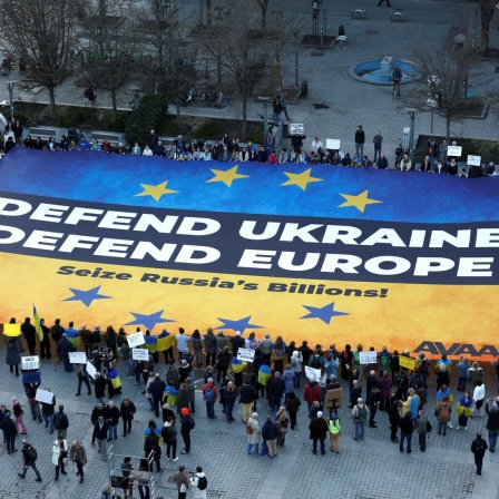 Aktivisten entrollen ein großes Transparent zur Unterstützung der Ukraine vor dem Gebäude des Europäischen Rates im Vorfeld eines EU-Gipfels in Brüssel.