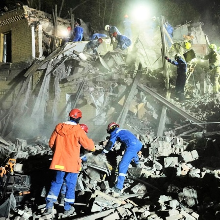 Ukrainische Helfer arbeiten in den Trümmern nach einem russischen Raketenangriff in Kiew, Ukraine, am frühen Donnerstag. Russland hat ukrainischen Angaben zufolge in der Nacht erneut mit Drohnen die ukrainische Hauptstadt Kiew angegriffen.