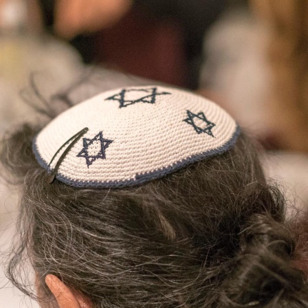 Ein Mann von hinten, der eine Kippa mit Davidstern trägt