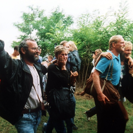 Jubelnde DDR-Flüchtlinge gelangen am 19.08.1989 über Ungarn nach Österreich.