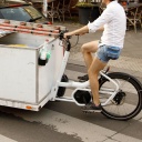 Ein Mann fährt auf einem Lastenrad.