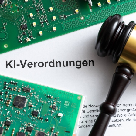Dokument mit Computerplatine und Richterhammer mit Aufschrift: KI Verordnungen.