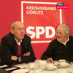 2 Männer sitzen vor einem SPD-Aufsteller