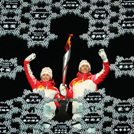 Die uigurische Langläuferin Dinigeer Yilamujian entzündet das Olympische Feuer bei den Winterspielen in Peking.