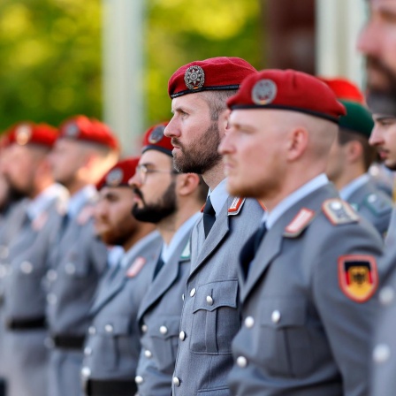 Soldaten stehen stramm beim Indienststellungsappell des Unterstützungskommandos der Bundeswehr auf der Hardthöhe in Bonn. Die Soldaten tragen ein rotes Barett und graue Uniformen.