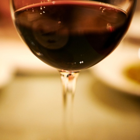 Foto eines Rotweinglases auf einem Tisch.