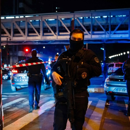 Ein Polizeibeamter steht am Tatort in Paris Wache.