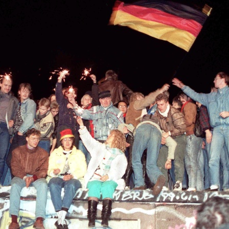 Berlin, 10.11.1989 Mit Wunderkerzen in den Händen freuen sich die Menschen auf der Berliner Mauer über die Öffnung der deutsch-deutschen Grenzen.