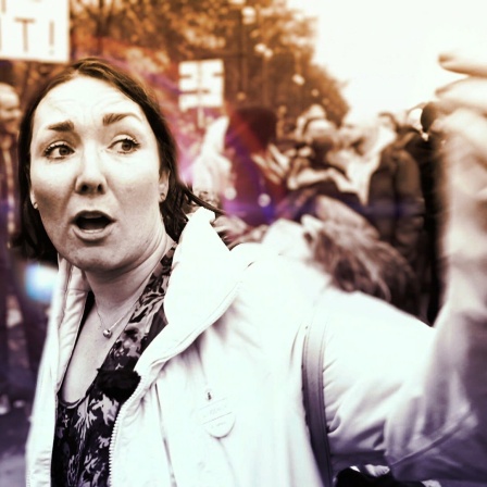 Szene aus "Querdenker: Wie sich Menschen aus der Mitte radikalisieren" - Protagonistin während einer Querdenken Demonstration in der Menge.