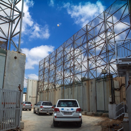Gepanzerte Fahrzeuge passieren die mit meterhohen Mauern und Drahtzäunen gesicherte Grenze zwischen dem Gaza-Streifen und Israel, um Entwicklulngshilfe zu leisten.