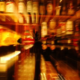 Blick in eine mit Alkohol gefüllte, beleuchtete Bar