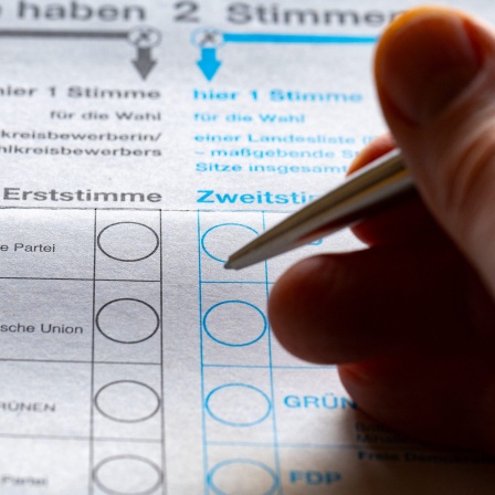 Hand mit Stift auf Stimmzettel