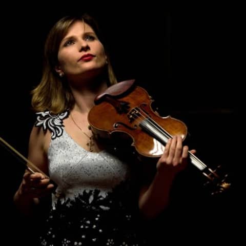 Lisa Batiashvili mit der Geige in der Hand vor einem schwarzen Hintergrund.
