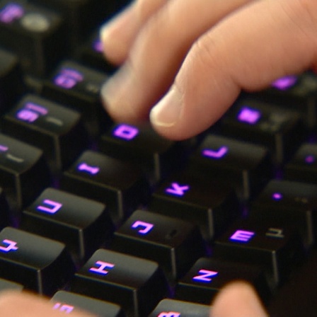 Zwei Hände schreiben auf einer Tastatur