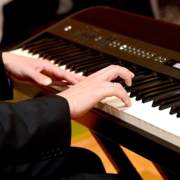 Ein Musiker spielt während einer Feier auf einem E-Piano.