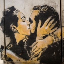 Wandzeichnung zweier sich küssender Menschen.