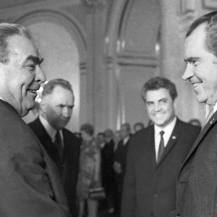 Leonid Iljitsch Breschnew, Generalsekretär der KPdSU, begrüßt US-Präsident Richard Nixon am 23. Mai 1972 in Moska. Im Hintergrund Dolmetscher