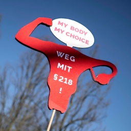 Auf einer Demonstration in Berlin zum Weltfrauentag ist ein Schild in Form einer Gebärmutter zu sehen. Darauf steht: "My body, my choice - weg mit §218!"