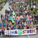 Teilnehmer eines Demonstrationszuges von Fridays for Future tragen ein Banner mit dem Text "Klimastreik".